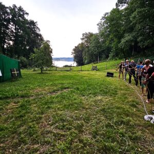 Menschen beim Bogenschießen im Freien auf einer Wiese bei Baum & Bogen.